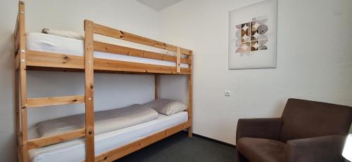 a bedroom with two bunk beds and a chair at Urlaub by Julka in Ledenitzen