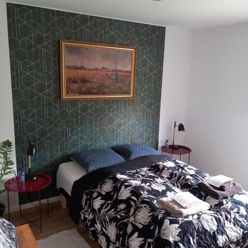 ein Schlafzimmer mit einem Bett und einem Gemälde an der Wand in der Unterkunft Leons House in Bindslev