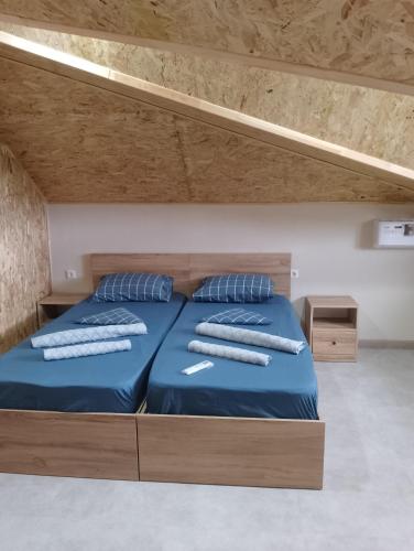 a bedroom with two beds with blue sheets and pillows at Hotel Nia in Ureki
