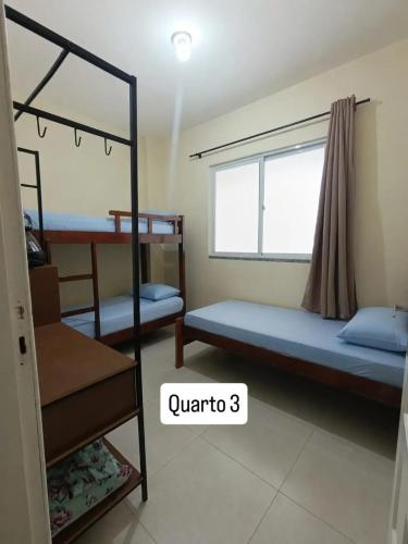 a bedroom with two bunk beds and a window at Apartamento Castelhanos Anchieta in Anchieta