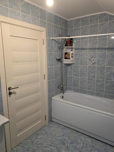 a bathroom with a tub and a white door at Vila Pângărați in Pangarati