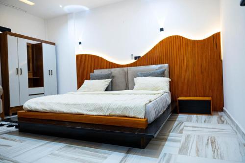 a bedroom with a large bed with a wooden headboard at Mandys Guest House in Yaoundé