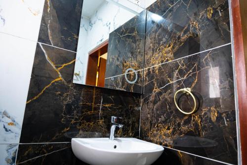 a bathroom with a sink and a mirror at Mandys Guest House in Yaoundé