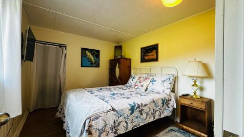 a bedroom with a bed and a lamp on a table at The Cottage on the Farm in Ladysmith