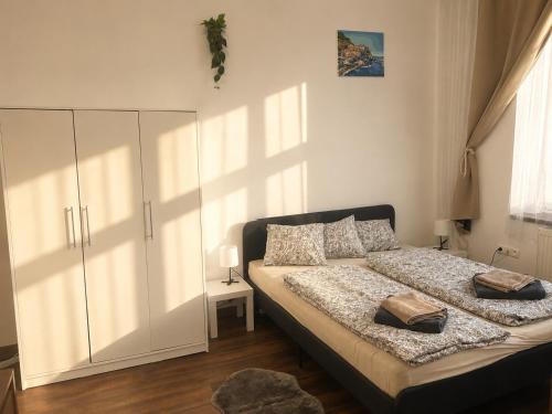 a bedroom with a bed and a large white cabinet at Apartman Hasičská in Trenčín