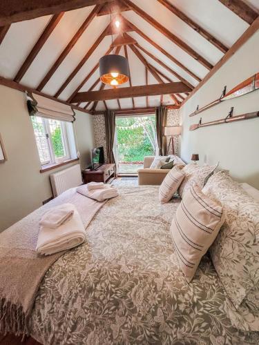 a bedroom with a large bed with pillows on it at The Willow Nest in Hambleden