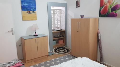 a bedroom with a bed and a cabinet and a mirror at Katata Apartment One -Bedrom in Podgorica