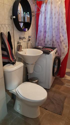 a bathroom with a white toilet and a sink at Katata Apartment One -Bedrom in Podgorica