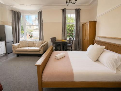 a hotel room with a bed and a living room at 55 Studio 1 Uplands in Swansea
