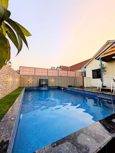 a swimming pool with blue water in front of a building at Indraprastha villa in Malavli