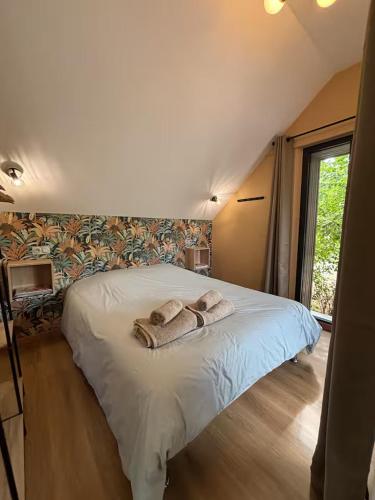 a bedroom with a bed with two towels on it at Charmante maison indépendante avec jardin, 45 m2, clim, parking in Mondeville