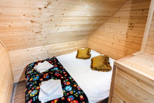 a small room with a bed in a wooden cabin at OlszeVita in Szteklin