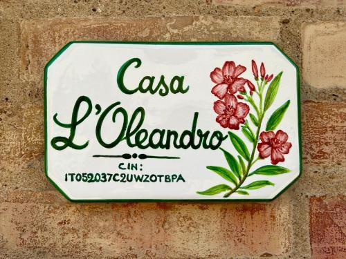 a sign on a wall with flowers on it at Casa L Oleandro in Torrenieri
