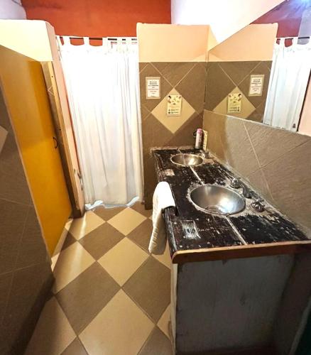 a bathroom with a sink and a tiled floor at Hostal Humahuaca in Humahuaca