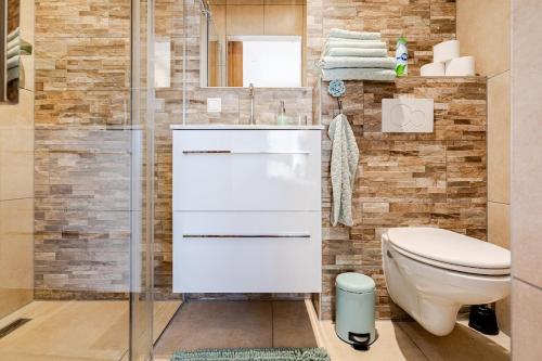 a bathroom with a toilet and a glass shower at Lou-Lou in Zandvoort