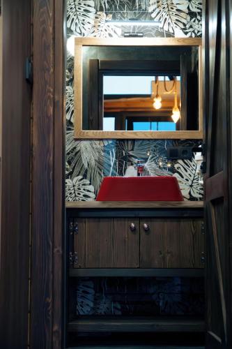 a bathroom with a mirror and a red sink at Ötüken Dağ Evleri in Akcaabat