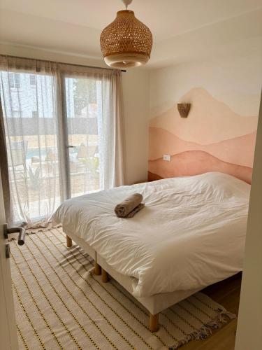 a bedroom with a bed and a large window at Doudou House in Saint-Denis-dʼOléron