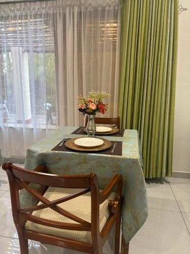 a dining room table with a vase of flowers on it at Dopiro Lodge and Gardens in Nyanda