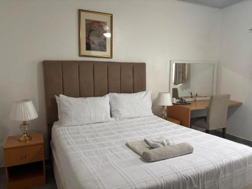a bedroom with a bed with a towel on it at Dopiro Lodge and Gardens in Nyanda