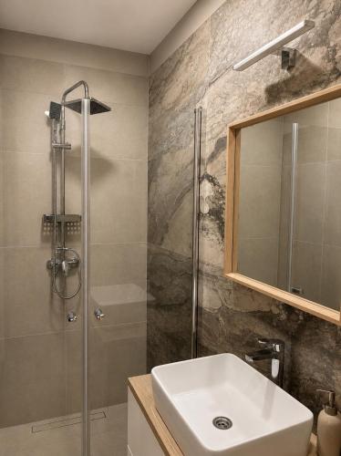 a bathroom with a sink and a shower at Barcs Thermal Apartments in Barcs
