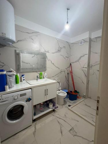 a bathroom with a washing machine and a sink at Florida apartments in Golem