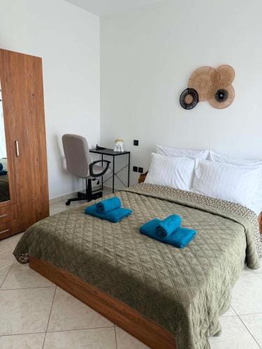 a bedroom with a bed with blue pillows on it at The View Xanthi in Xanthi