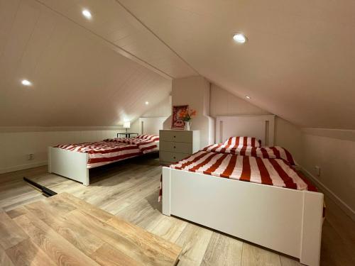 a attic bedroom with two beds in a room at Mysigt stuga med bastu in Edsvalla