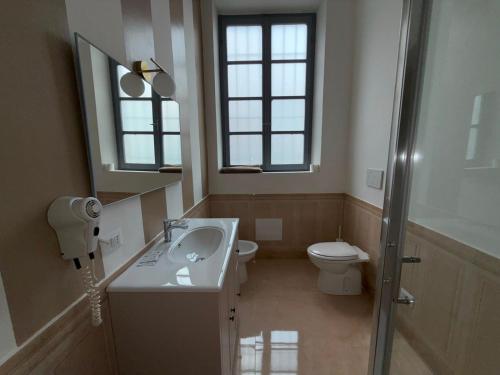 a bathroom with a sink and a toilet and a mirror at Palazzo TEDESCHI in Borgonovo Val Tidone