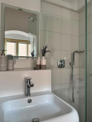 a white bathroom with a sink and a shower at Ferienwohnung Sonnenblick in Hinterstoder