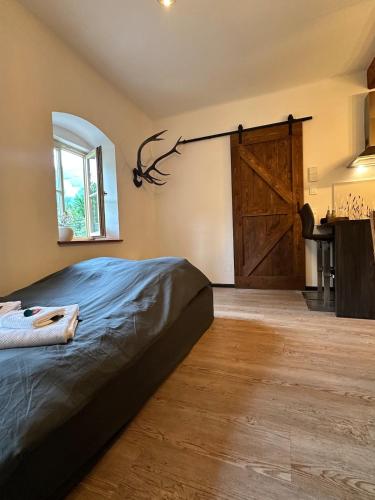 a bedroom with a bed and a large wooden door at Ferienwohnung Sonnenblick in Hinterstoder
