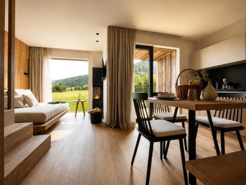 a living room with a bed and a table with chairs at AMIL chalets dolomites - Guests aged 14 and over in Arnbach