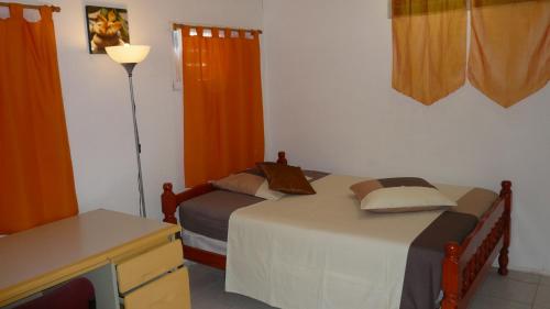 a bedroom with two beds and a dresser and a desk at villa NYL in Schœlcher