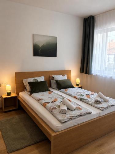 a large bed in a bedroom with two lamps at Barcs Thermal Apartments in Barcs