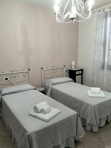 a bedroom with two beds and a chandelier at appartamento Podere i Renai in Santa Maria a Monte