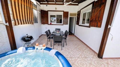 a room with a bath tub and a dining table at La Casa Créole, spa, 3 ch, 2 sdb, centre de la Guadeloupe in Les Abymes