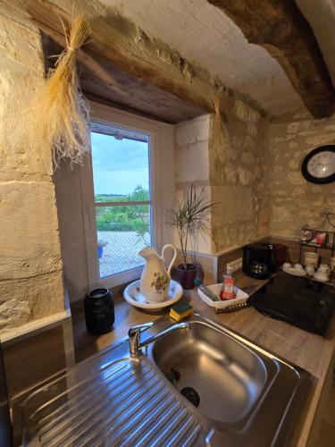 a kitchen with a sink and a window at L'Authentique in Mouzay
