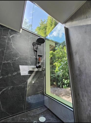 a bathroom with a shower with a large window at Mysigt stuga med bastu in Edsvalla