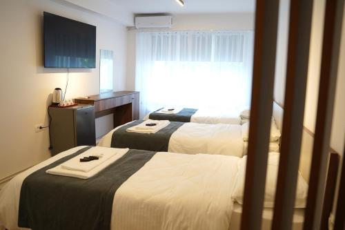 a hotel room with two beds and a window at Parkside Boutique Hotel in Prishtinë