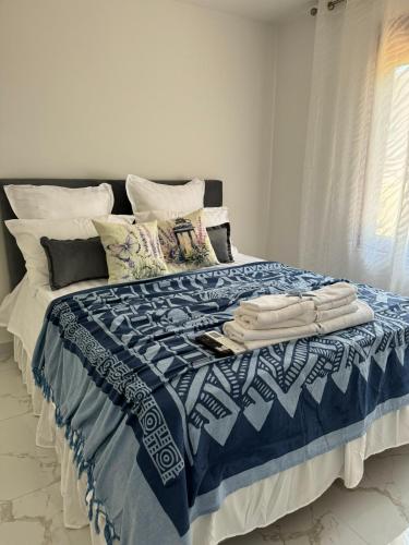a bed with a blue and white blanket and pillows at Luka Vacation House in Ulcinj