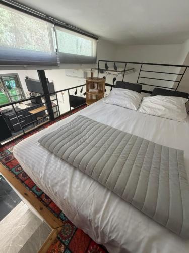 a large white bed in a room with a window at Sweet in Nahariyya