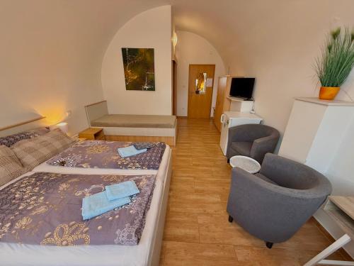 a bedroom with a bed and a couch and a chair at Penzion u Pidly in Mariánské Lázně