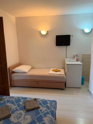 a small room with a bed and a tv at Apartman Luka Pogled na more in Neum