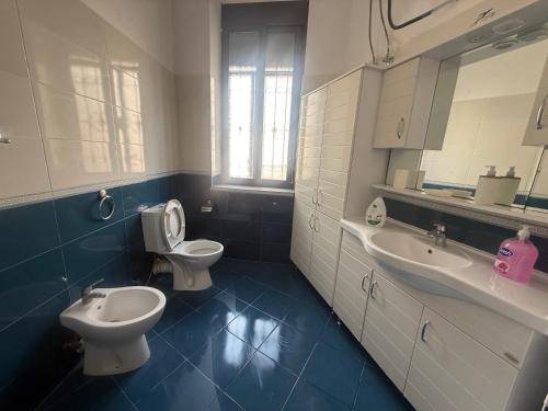 a bathroom with two sinks and a toilet and a mirror at Star Apartment 2- Spacious in the heart of Durres in Durrës