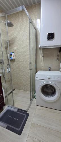 a washing machine in a bathroom with a shower at Azure Horizon Pržno in Sveti Stefan