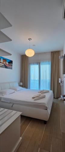 a bedroom with a large bed and a chandelier at Azure Horizon Pržno in Sveti Stefan