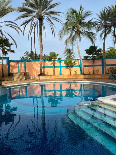 a swimming pool with palm trees in the background at Residencia manatial in La Mira