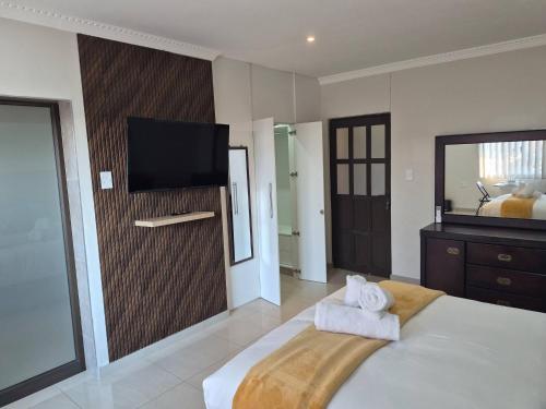 a bedroom with a large bed with towels on it at Nombelas Cottage in Westville
