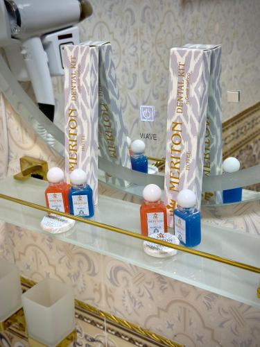 a shelf with three awards and bottles of honey at Meriton Hotel Bukhara in Bukhara