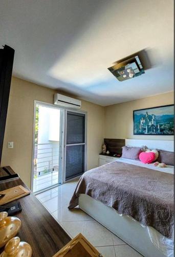 a bedroom with a bed and a large window at Pousada Recanto do Bosque in Luziânia