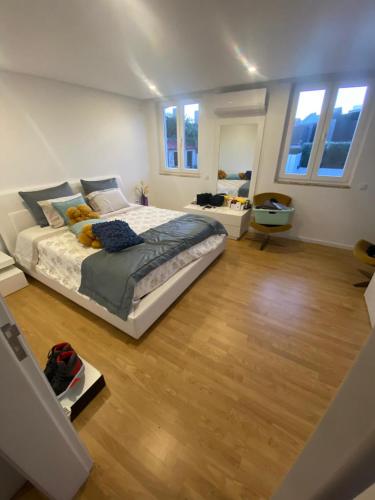 a large bedroom with a large bed and wooden floors at Casa dos Paralelos RC in Moledo